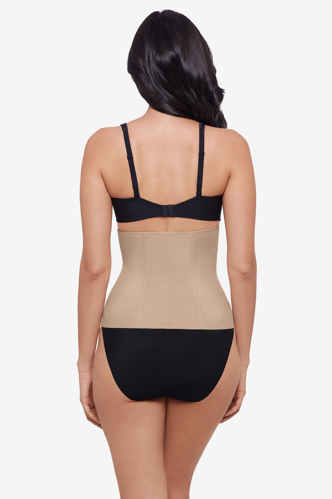 Woman turned away wearing a warm beige waist cincher