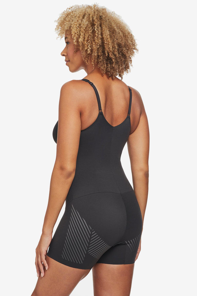 Woman turned away wearing black one-piece thigh slimming shapewear