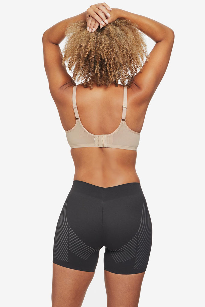 Woman turned away wearing black bike short shapewear