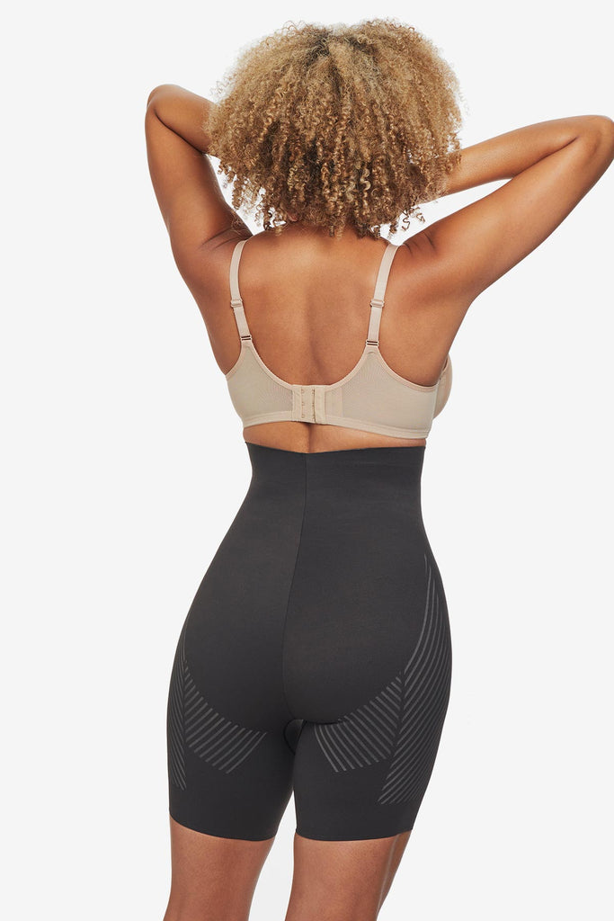 Woman turned away wearing black high waisted bike short shapewear