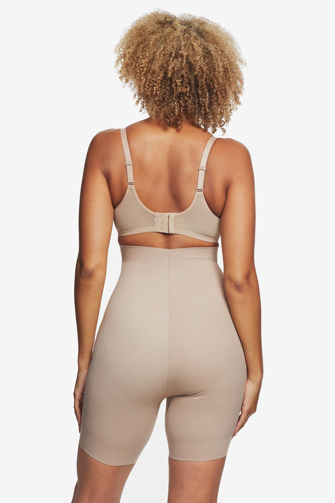 Woman turned away wearing tan high waisted bike short shapewear