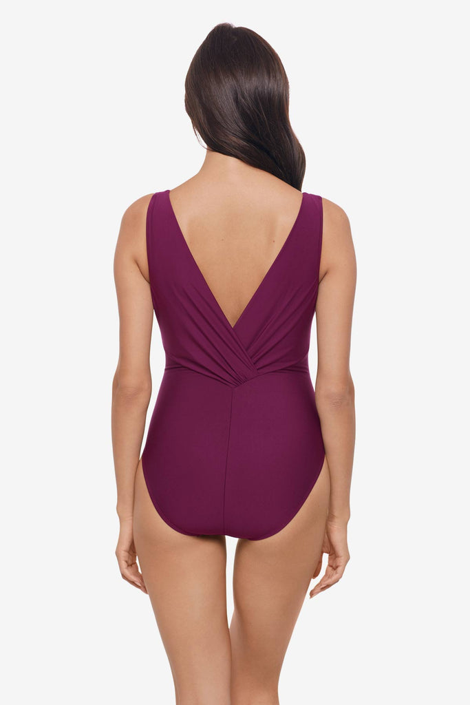 Woman faced away wearing a purple one-piece swimsuit