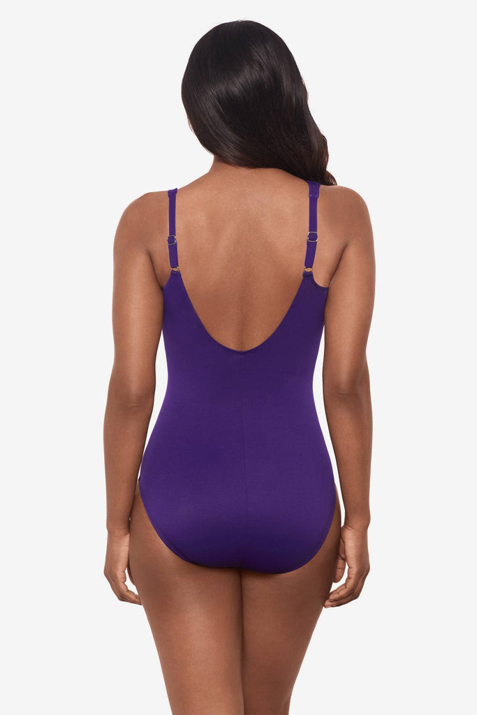 Woman facing away  wearing a mulberry purple one-piece swimsuit 