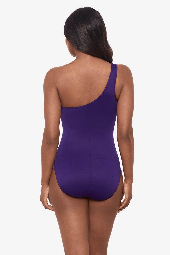 Woman facing away wearing a mulberry purple one-piece swimsuit 