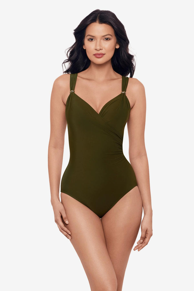 Woman wearing a nori green one-piece swimsuit with details on the straps