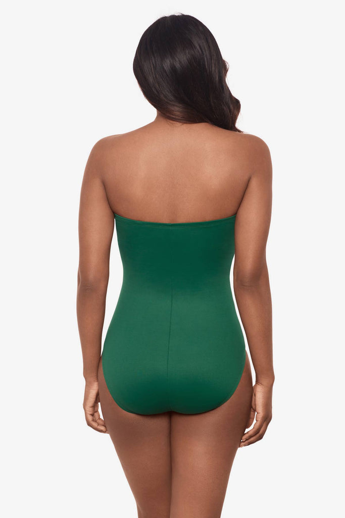 Woman facing away wearing a strapless malachite green one-piece swimsuit 