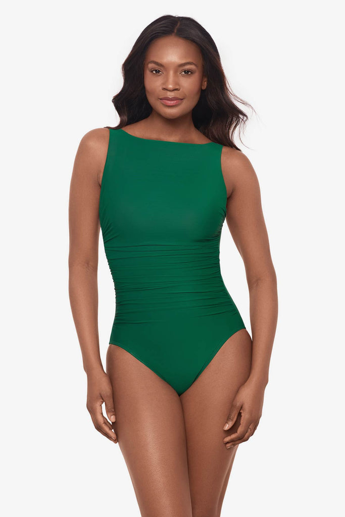 Woman wearing a malachite green one-piece swimsuit with a high neckline