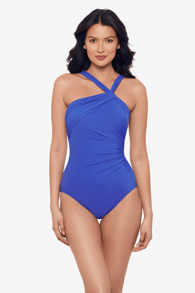 Woman wearing a delphine blue one-piece swimsuit with a strappy neckline