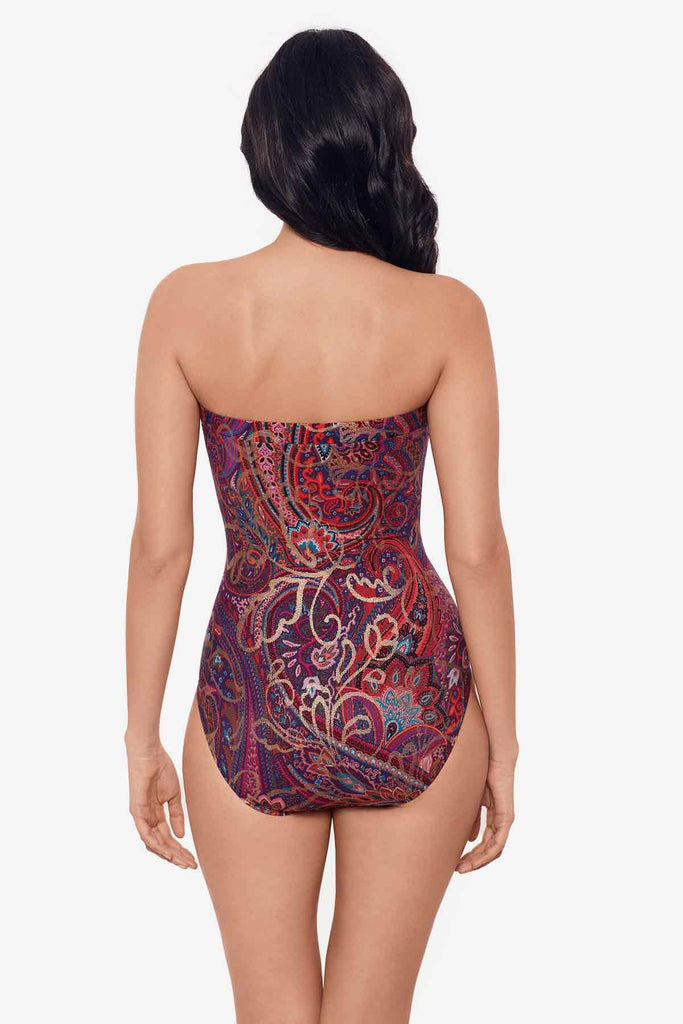 Woman faced away wearing a bandeau one-piece swimsuit with an abstract print