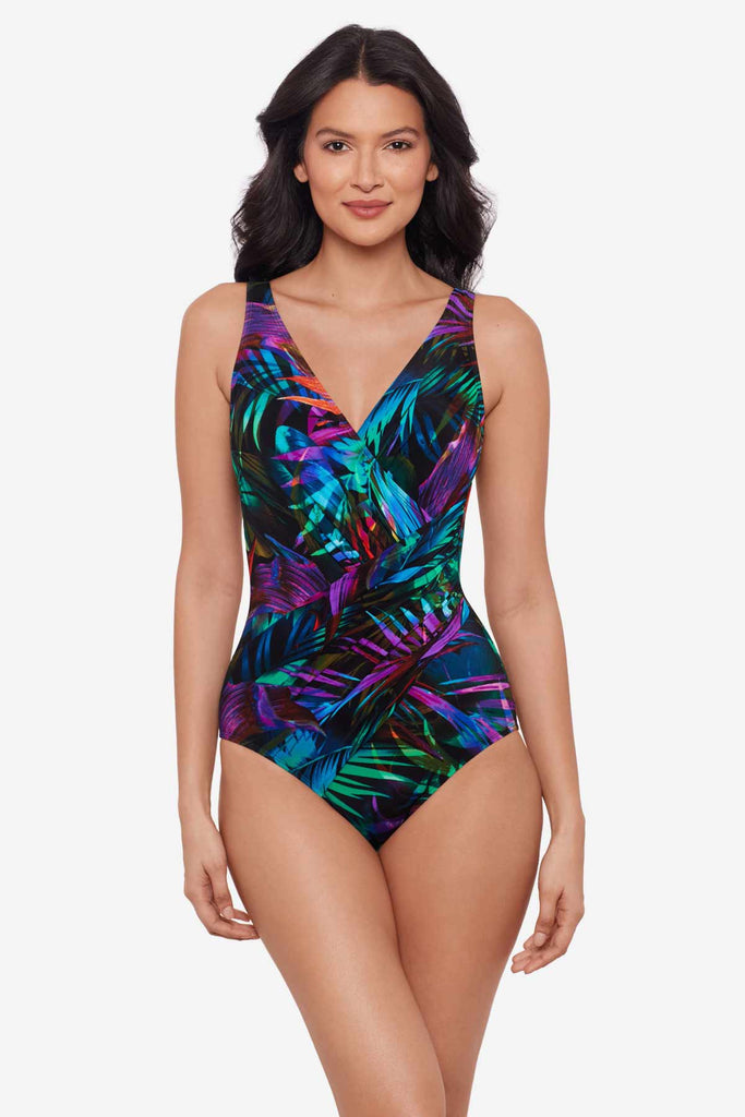 Woman wearing a multicolor one-piece swimsuit with neon palm leaves