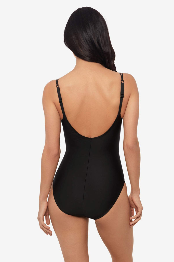 Woman faced away wearing a black one-piece swimsuit 