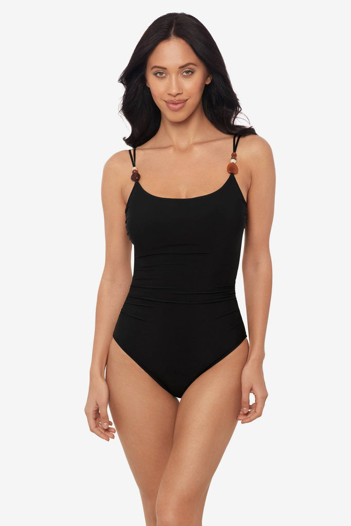 Woman wearing a black one-piece swimsuit with beads on the straps