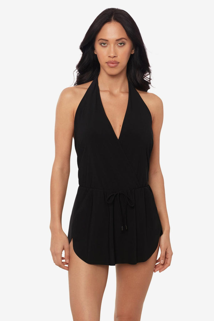 Woman wearing a black swim romper with a deep v-neck