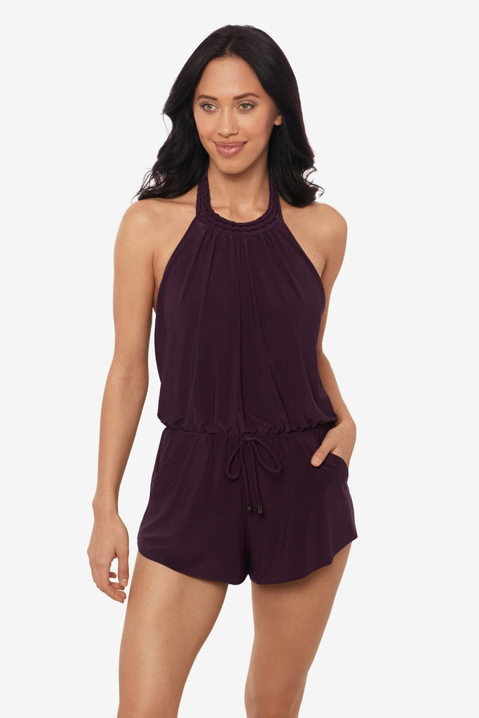 Woman wearing a prune purple swim romper with a high neckline