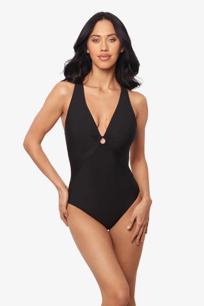 Woman wearing a black one-piece swimsuit with a deep V-neck