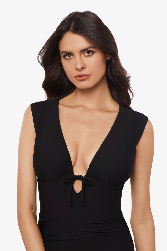 Close up of woman wearing a black one-piece swimsuit with a deep v-neck