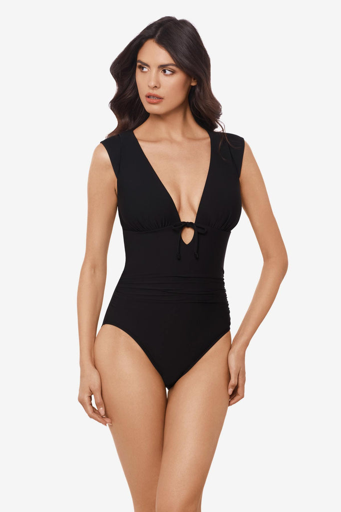 Woman wearing a black one-piece swimsuit with a deep v-neck