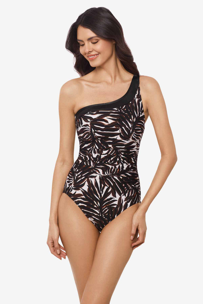 Woman wearing a multicolor one-piece swimsuit with an asymmetrical cut