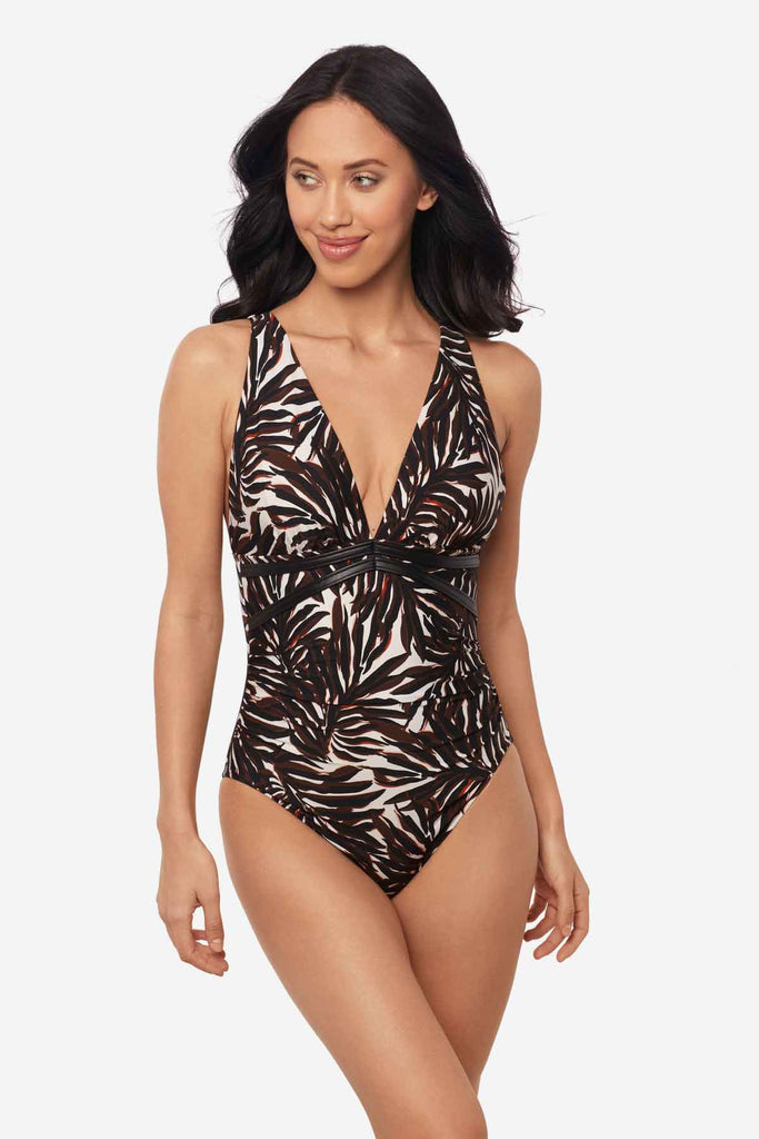 Woman wearing a multicolor one-piece swimsuit with a palm leaf print