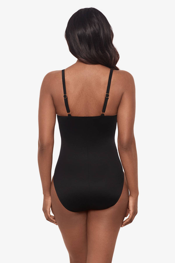 Woman facing away Woman wearing an all-black one-piece swimsuit 