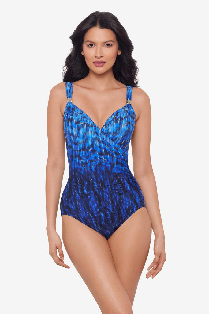 Woman wearing a black and blue one-piece swimsuit with details on the straps