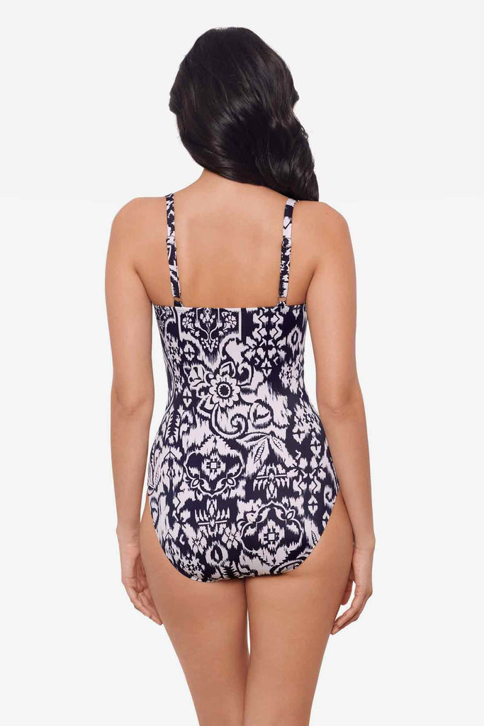 Woman facing away wearing a one-piece blue and white swimsuit 