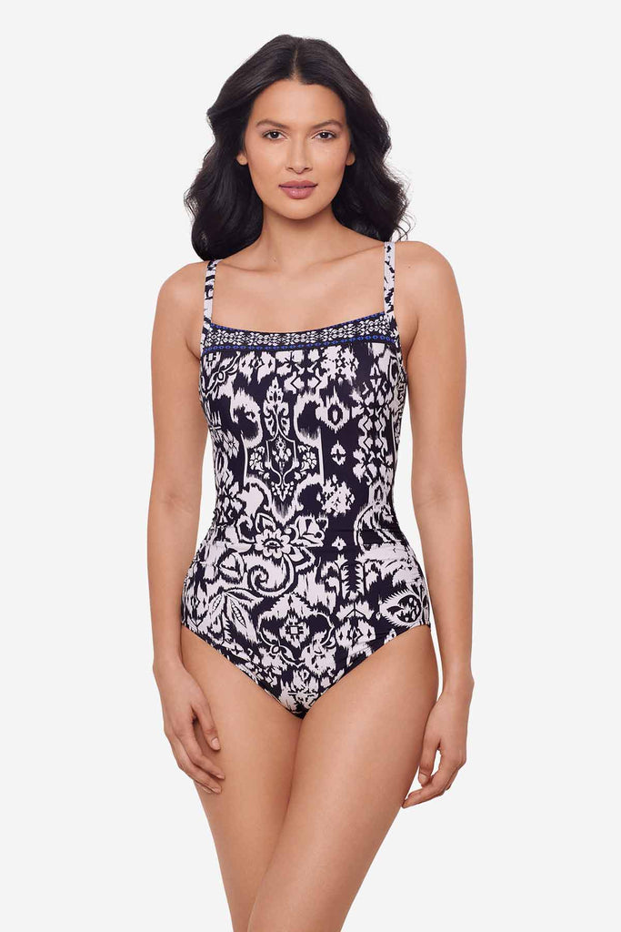 Woman wearing a one-piece blue and white swimsuit with an abstract floral print