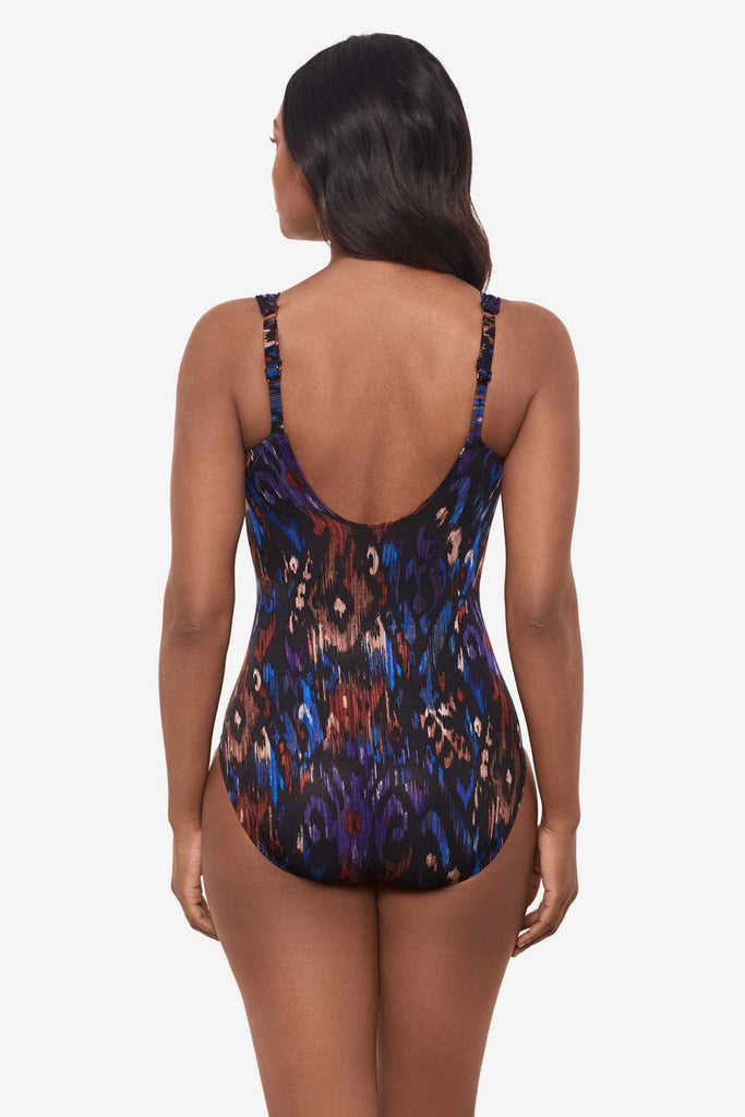 Woman facing away showing off the back of the multicolored one-piece swimsuit