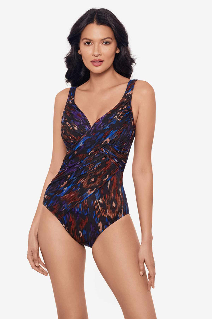 Woman wearing a one-piece swimsuit with a multicolor abstract pattern