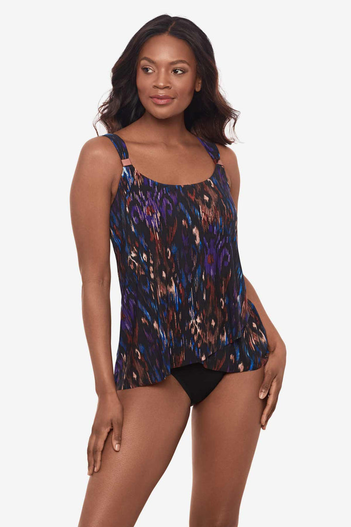 Woman looking away wearing a multicolored tankini swim top with detailing on the straps