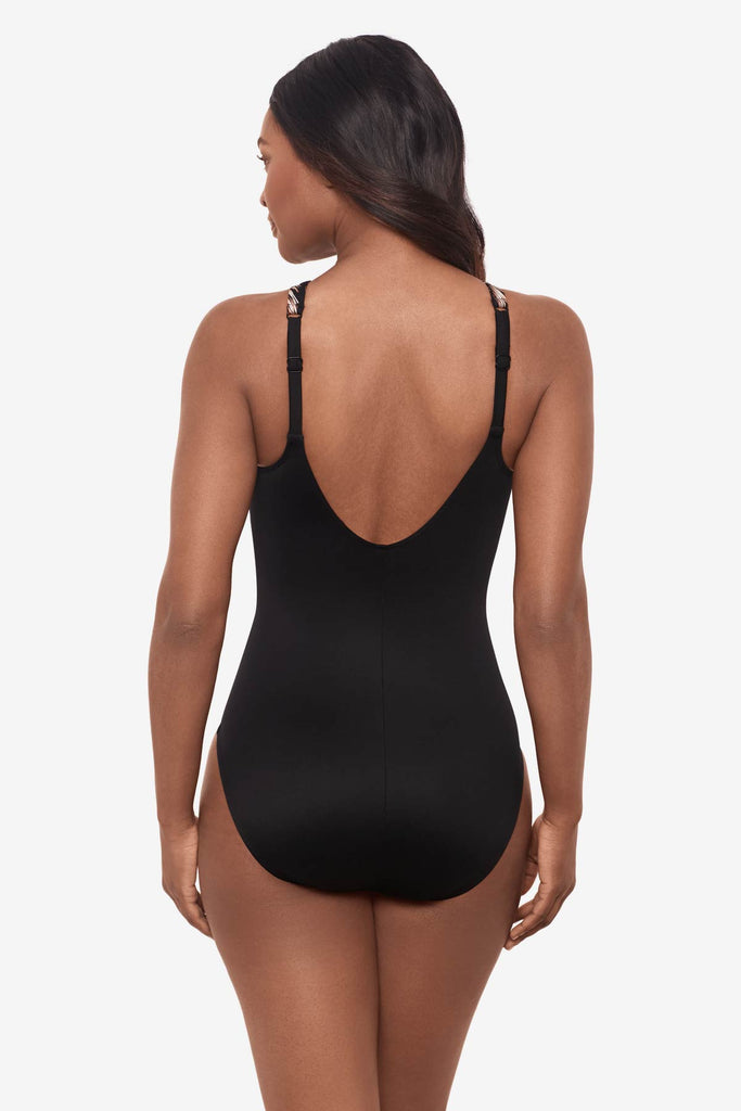 Woman facing away showing off the back of the one-piece swimsuit