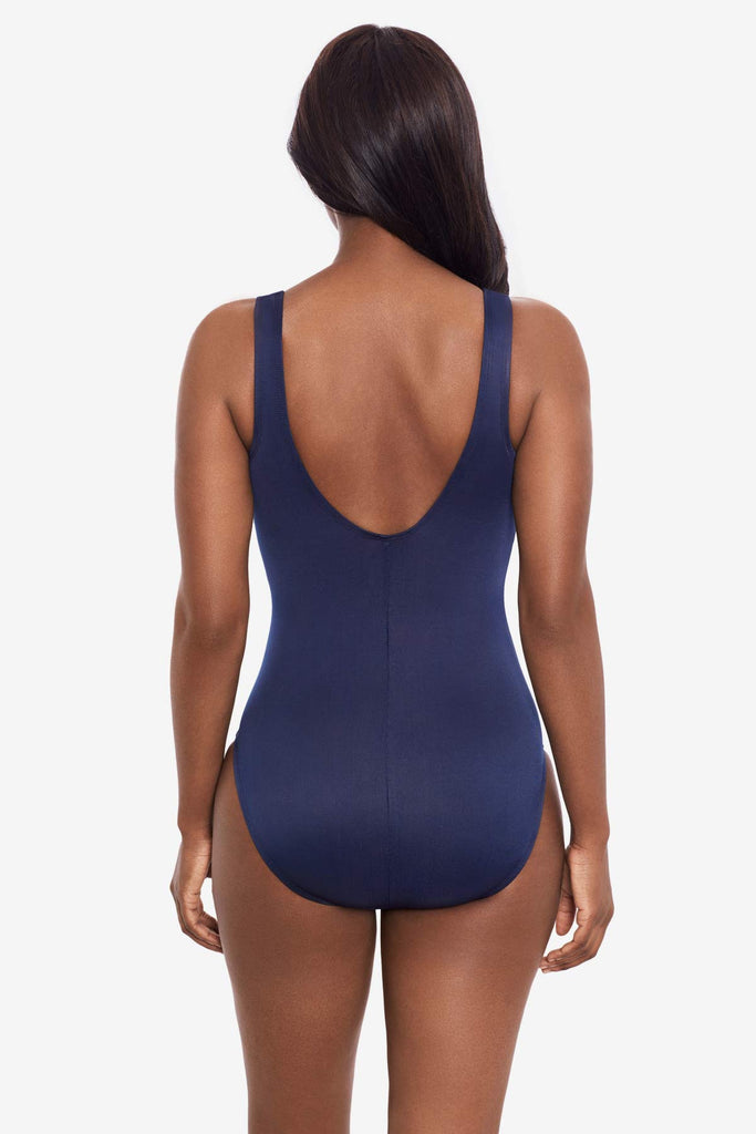 Woman facing away wearing a midnight blue one-piece swimsuit