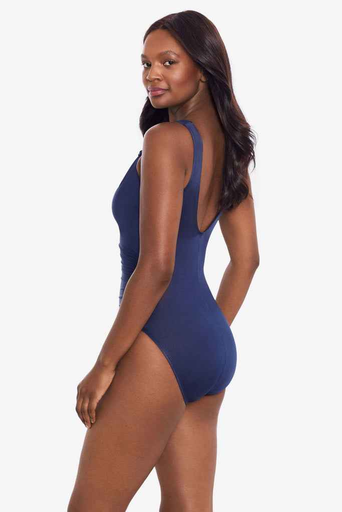 Woman turned to the side to show detail of one-piece swimsuit