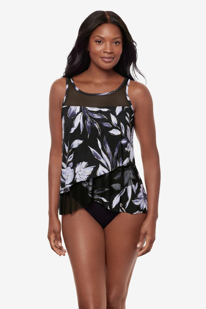 Woman wearing a black and white floral printed tankini top with mesh throughout