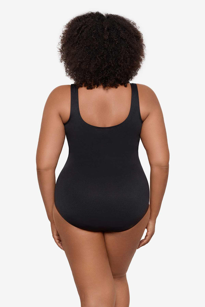 Woman turned away wearing a black one-piece swimsuit 