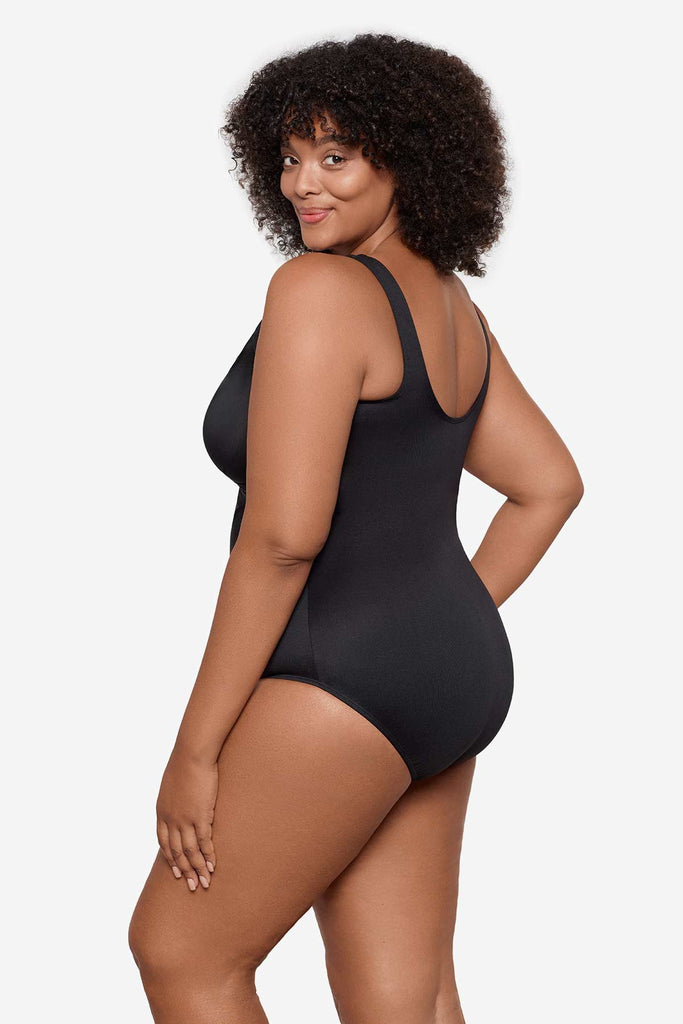 Woman turned to the side to show detail of one-piece swimsuit