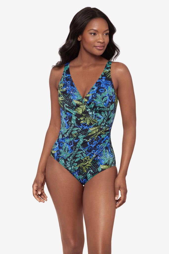 Woman wearing a blue and green abstract printed one-piece swimsuit