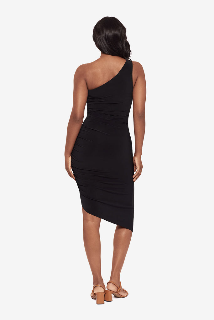 Woman faced away wearing a black one shoulder asymmetrical dress