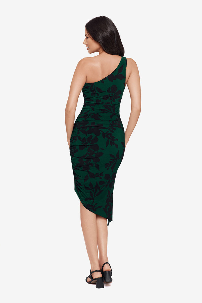 Woman turned away wearing a dark green dress with a black floral print