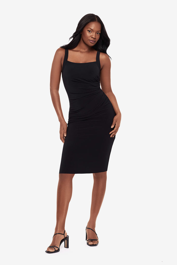 Woman wearing a black midi dress with a square neckline
