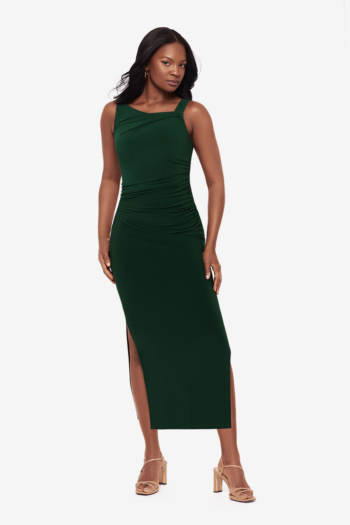 Woman wearing a dark green maxi dress with slits on both sides