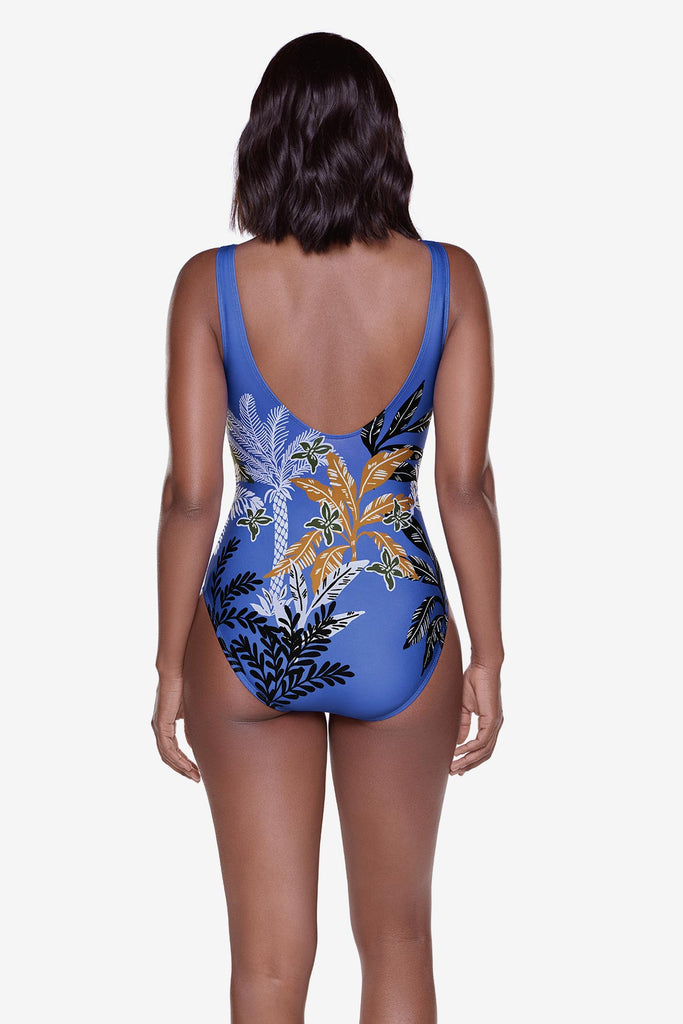 Woman turned away wearing a multicolored and multi-printed one-piece swimsuit