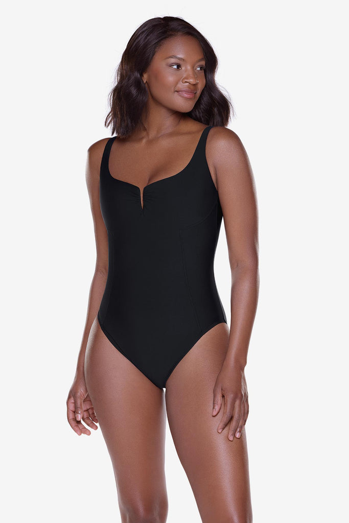 Woman wearing a black one-piece swimsuit with a slit at the neckline