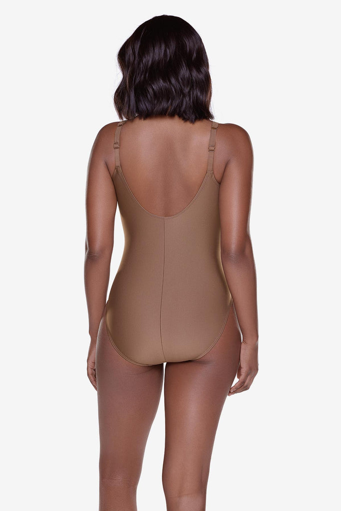 Woman turned away wearing a solid brown one piece swimsuit