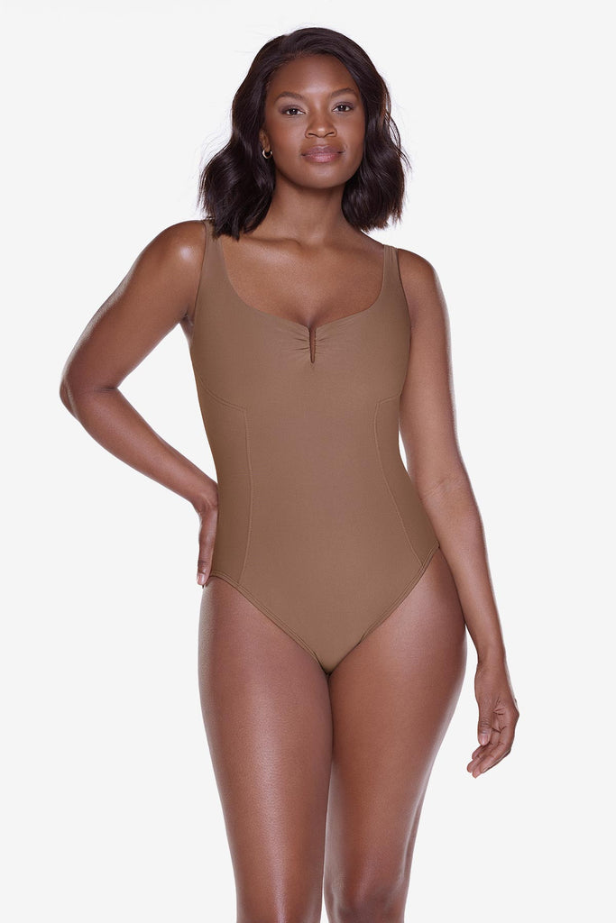Woman wearing a solid brown one piece swimsuit