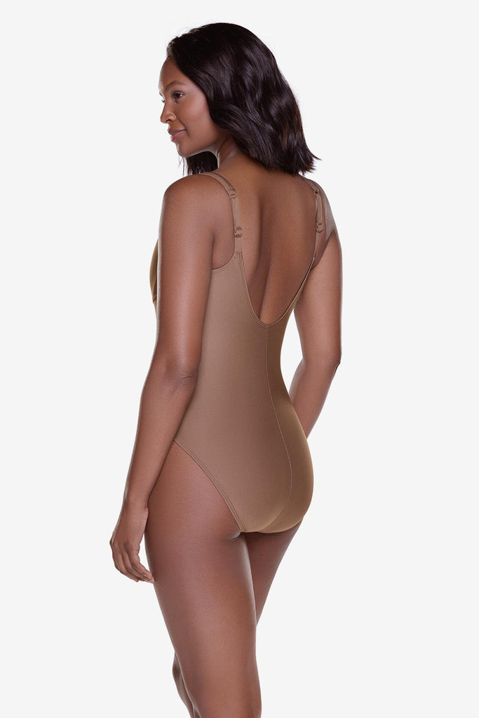 Woman turned left wearing a solid brown one piece swimsuit