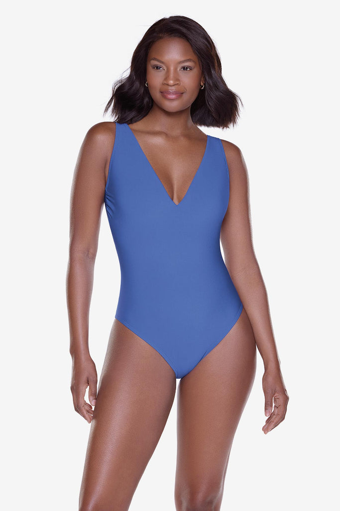 Woman wearing a blue one-piece swimsuit with a v-neckline