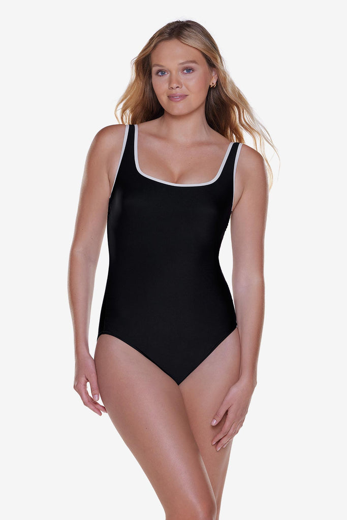 Woman wearing a black one-piece swimsuit with white piping