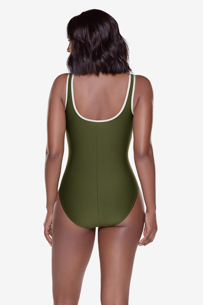 Woman turned away wearing a green one-piece swimsuit with white piping