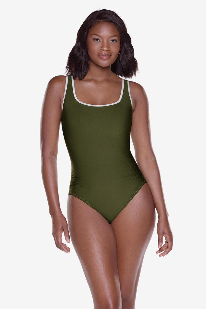 Woman wearing a green one-piece swimsuit with white piping